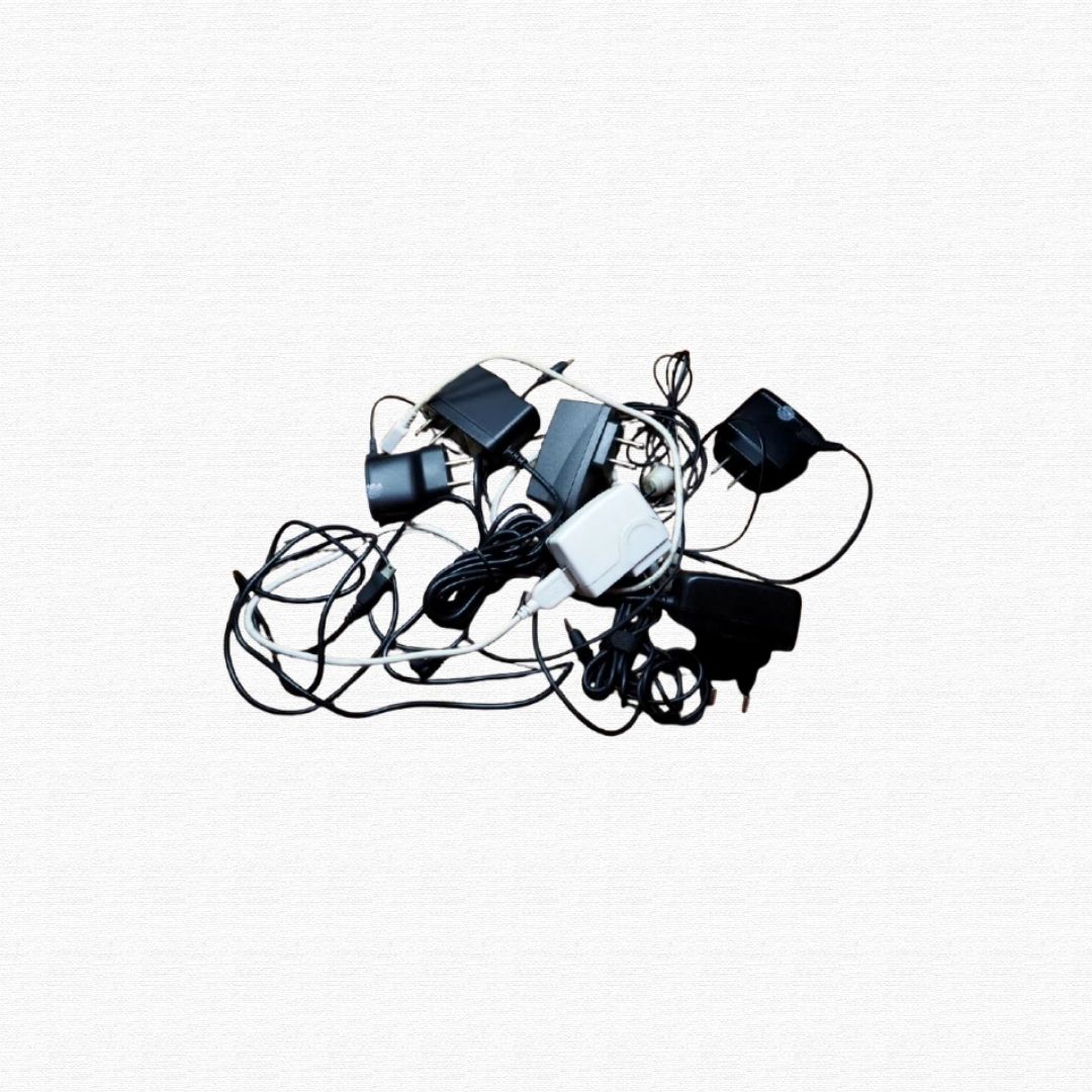 A tangled pile of USB cords, charging cables, and power adapters